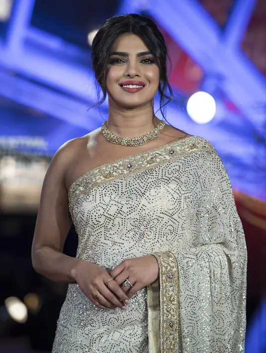 Aktris Priyanka Chopra tersenyum saat menghadiri Festival Film Internasional Marrakech ke-18 di Jemaa El Fnaa, Marrakech (5/12/2019). Priyanka Chopra tampil cantik memesona mengenakan busana sari emas dan brokat perak denga dengan kalung emas di lehernya. (AFP/Fadel Senna)