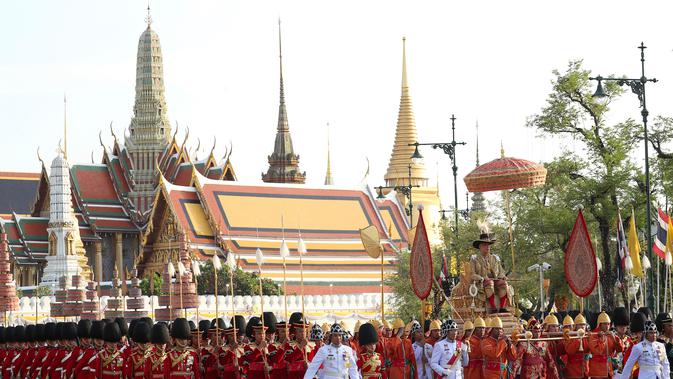 Raja Thailand Maha Vajiralongkorn diarak menggunakan tandu keliling Kota Bangkok, Thailand, Minggu (5/5/2019). Maha Vajiralongkorn diarak keliling Bangkok dengan tandu emas oleh para prajuritnya. (AP Photo/Rapeephat Sitichailapa)