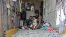 Seorang perempuan muda dan bayi beristirahat di tempat perlindungan darurat di Pemakaman Umum Selatan di Caracas, pada 16 Februari 2021. Makam yang dirusak telah menjadi rumah bagi banyak tunawisma di Venezuela. (Pedro Rances Mattey / AFP)