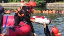 Dua mahasiswa membawa bendera merah putih turun ke dalam Setu Tujuh Muara untuk mengikuti upacara Bendera HUT Kemerdekaan RI ke 71, di Pamulang, Tangerang Selatan, Rabu (17/08). (Liputan6.com/Fery Pradolo)
