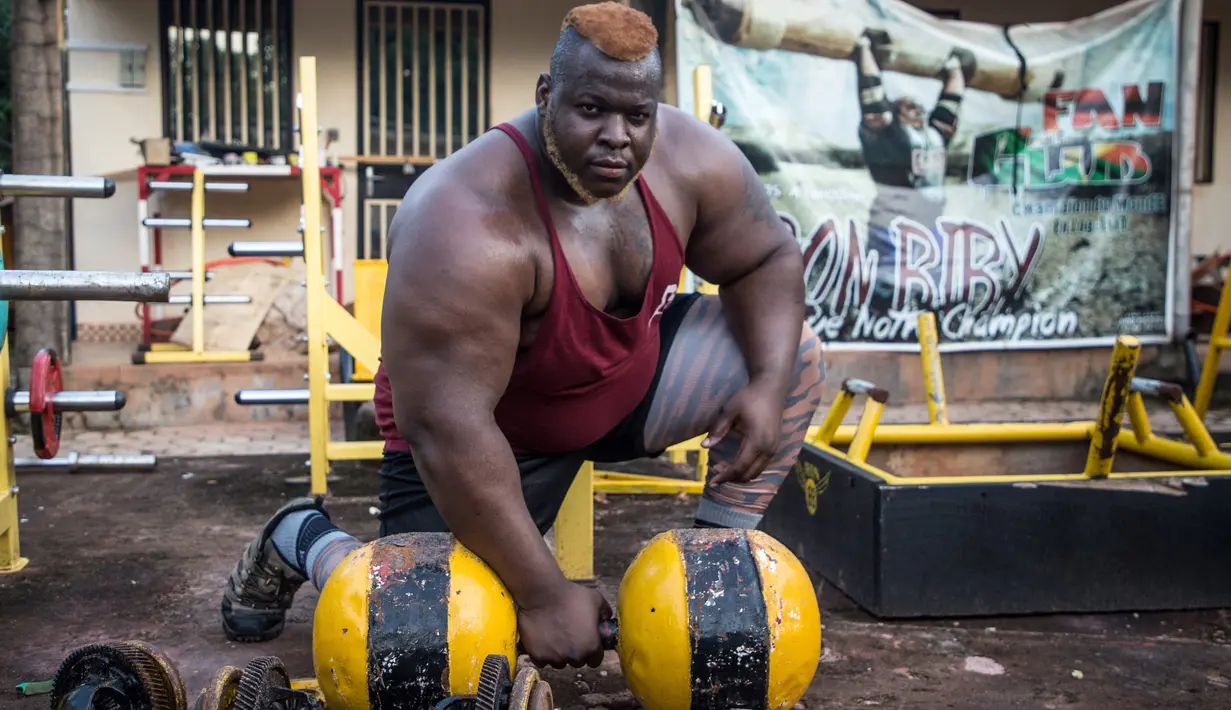 Iron Biby melakukan latihan di rumahnya di Bobo-Dioulasso, Burkina Faso pada 24 September 2018. April lalu, pria dengan berat badan 180 kg itu memenangkan kejuaraan dunia mengangkat batangan kayu seberat 230 kg. (OLYMPIA DE MAISMONT / AFP)