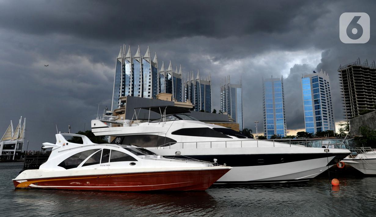 Kapal-kapal bersandar saat awan cumulonimbus menyelimuti perairan Teluk Jakarta, Minggu (10/1/2021). Sejak beberapa hari terakhir, perairan Teluk Jakarta diselimuti cuaca ekstrem yang berbahaya bagi pelayaran dan penerbangan. (merdeka.com/Arie Basuki)