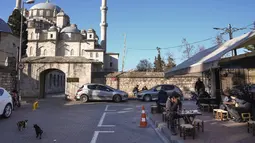 Orang-orang duduk di teras sebuah kedai kopi di sebelah masjid Fatih di Istanbul, Turki, Selasa, 3 Januari 2023. Ini merupakan bulan kedua secara berturut-turut, inflasi Turki mereda sejak merasakan rekor inflasi tertinggi selama 84 tahun sebesar 85,5 persen (yoy) pada Oktober 2022. (AP Photo/Khalil Hamra)