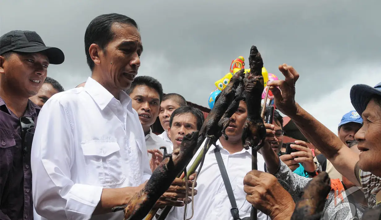 Saat melihat keadaan pasar, Jokowi ditawari tikus bakar oleh seorang pedagang di Pasar Tomohon, Sulawesi Utara, Sabtu (10/5/2014) (Liputan6.com/Herman Zakharia).