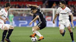 Aksi pemain Manchester United, Alexis Sanchez (tengah) mengecoh dua pemain Sevilla pada laga 16 besar Liga Champions di Ramon Sanchez Pizjuan stadium, Seville, (21/2/2018). Babak kedua Sevilla bermain imbang 0-0. (AP/Miguel Morenatti)