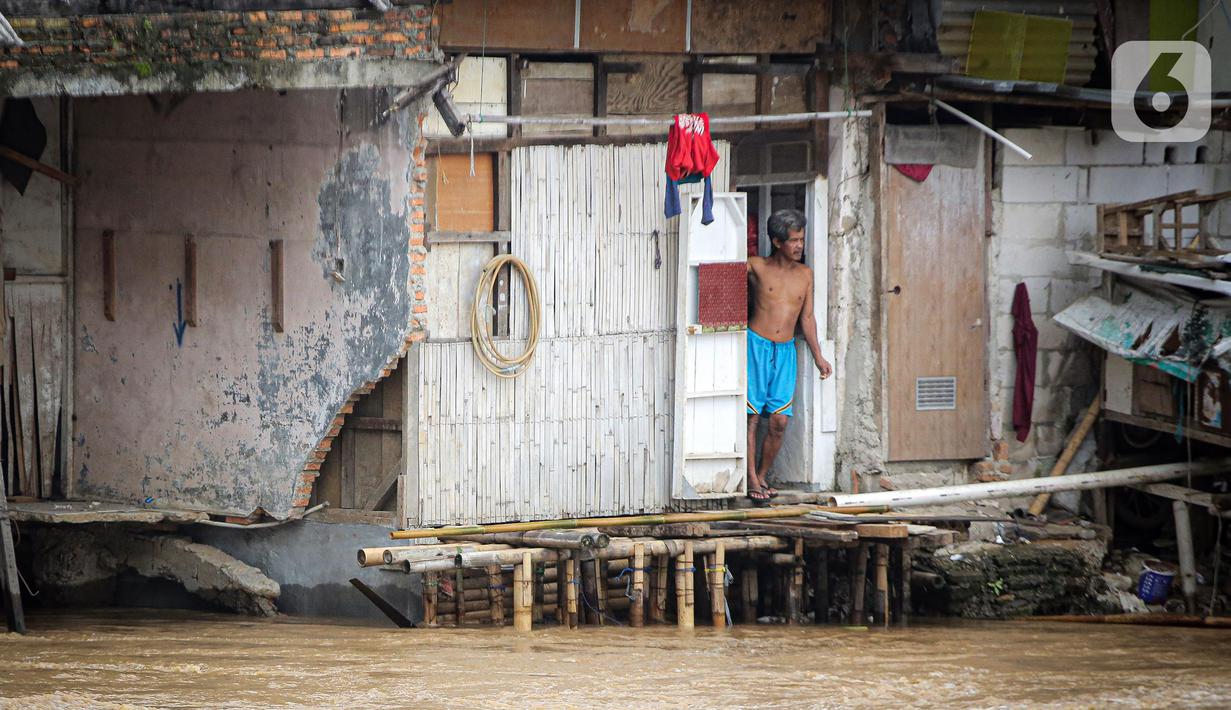 Warga permukiman bantaran Sungai Ciliwung menyaksikan banjir, Jakarta, Senin (10/10/2022). Hingga pukul 09.00 WIB hari ini, Badan Penanggulangan Bencana Daerah (BPBD) DKI Jakarta mencatat sebanyak 68 RT di Jakarta terendam banjir akibat luapan Sungai Ciliwung. (Liputan6.com/Faizal Fanani)