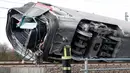 Seorang petugas pemadam kebakaran memeriksa gerbong kereta yang tergelincir, dekat Lodi, Italia utara, Kamis (6/2/2020). Kereta berkecepatan tinggi itu keluar dari rel hingga menewaskan sedikitnya dua orang dan sekitar 30 lainnya luka dalam insiden itu. (AP/Antonio Calanni)