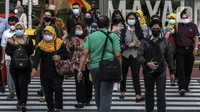 Aktivitas pekerja pada saat jam pulang kantor di kawasan Sudirman, Jakarta, Selasa (18/5/2021). Kamar Dagang dan Industri bersama pemerintah telah resmi memulai program Vaksinasi Gotong Royong untuk para pekerja swasta. (Liputan6.com/Johan Tallo)