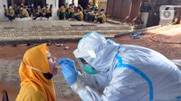 Santri melakukan swab test di Pondok Pesantren Baitul Hikmah, Bojongsari, Depok, Jawa Barat, Kamis (12/11/2020). Swab test massal dilakukan menyusul ditemukannya paparan COVID-19 terhadap seorang santri dan untuk memutus mata rantai penyebaran. (merdeka.com/Arie Basuki)
