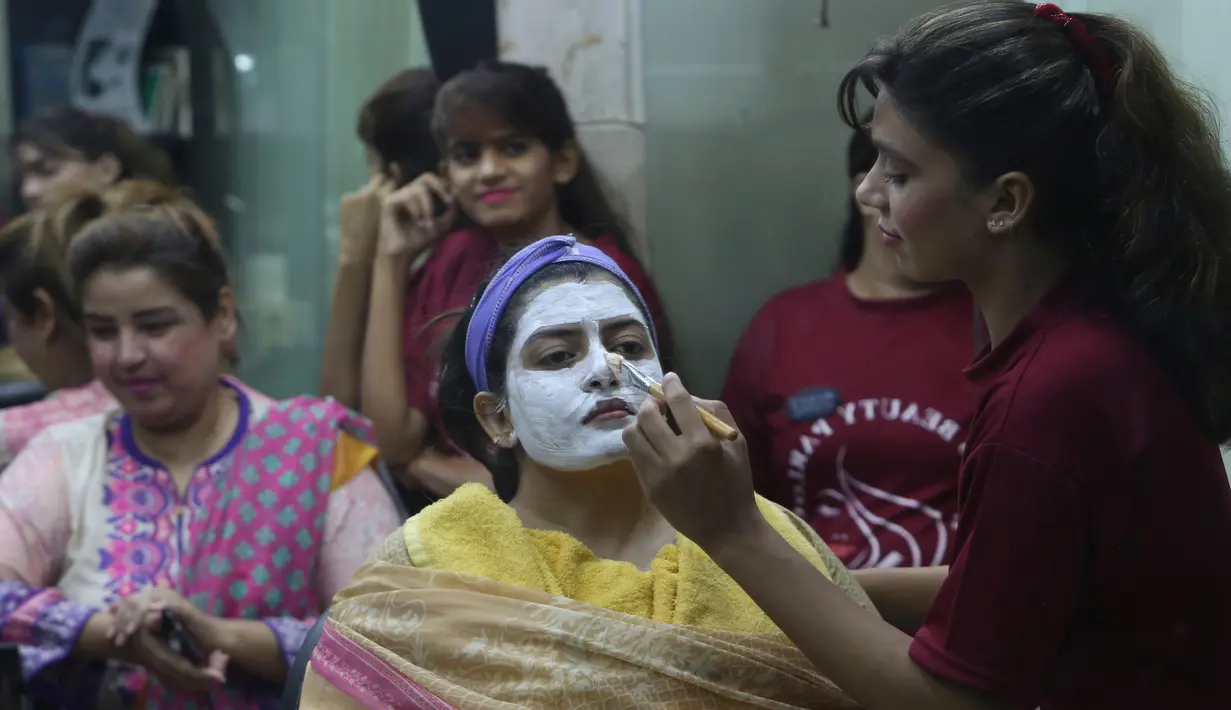 Seorang wanita Pakistan saat dibersihkan wajanya untuk persiapan Hari Raya Idul Fitri di Karachi (3/6/2019). Umat Muslim di seluruh dunia sedang bersiap untuk merayakan Hari Raya Idul Fitri, yang menandai akhir bulan puasa Ramadan. (AP Photo/Fareed Khan)