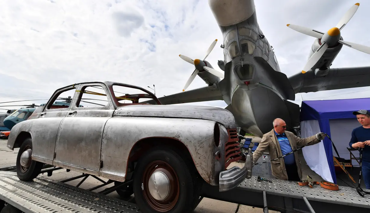 Peserta menurunkan mobil selama hari pembukaan festival mobil retro OldCarLand di Kiev (27/4). Lebih 1000 kendaraan yang dibuat di AS, Eropa dan Uni Soviet periode 1930-1970 dipamerkan bersama dengan 90 pesawat Uni Soviet. (AFP Photo/Sergei Supinsky)