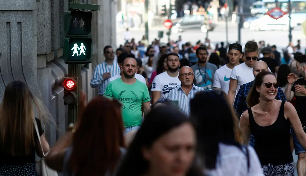 Sejumlah orang melewati lampu lalu lintas untuk pejalan kaki khusus pasangan sesama jenis di Madrid, Selasa (6/6). Pemasangan lampu lalu lintas ini bagian dari penyambutan Festival WorldPride yang digelar akhir bulan ini di Madrid. (OSCAR DEL POZO/AFP)