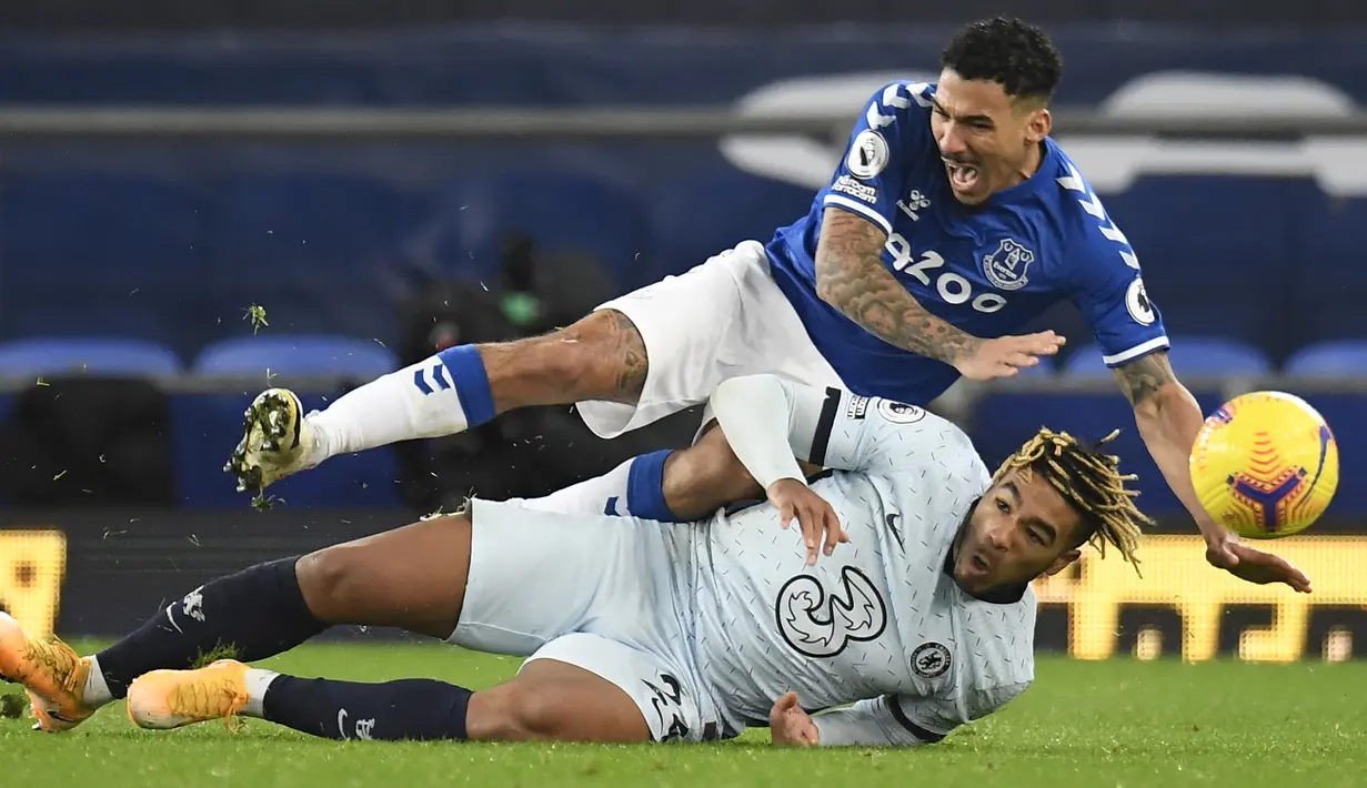 Bek Chelsea, Reece James (bawah), menjatuhkan gelandang Everton, Allan, dalam laga lanjutan Liga Inggris 2020/21 pekan ke-12 di Goodison Park Stadium, Sabtu (12/12/2020). Chelsea kalah 0-1 dari Everton. (AFP/Peter Powell/Pool)