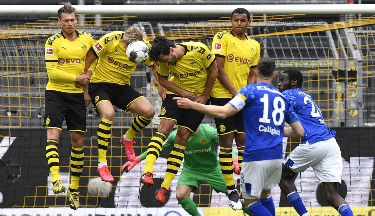 Para pemain Borussia Dortmund berusaha menghadang tendangan pemain Schalke 04, Daniel Caligiuri, pada laga Bundesliga di Stadion Signal Iduna Park, Sabtu (16/5/2020). Dortmund menang 4-0 atas Schalke 04. (AP/Martin Meissner)