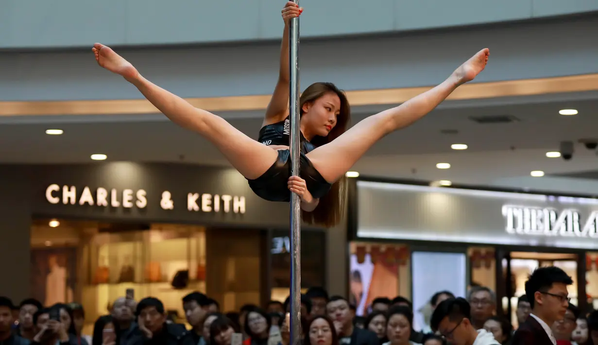 Seorang peserta mengambil bagian dalam kontes Pole Dance di sebuah pusat perbelanjaan di Shenyang, Liaoning, China, 4 April 2017. Pole Dance merupakan bentuk seni pertunjukan yang menggabungkan tari dan akrobat yang menggunakan tiang. (AFP PHOTO/STR)