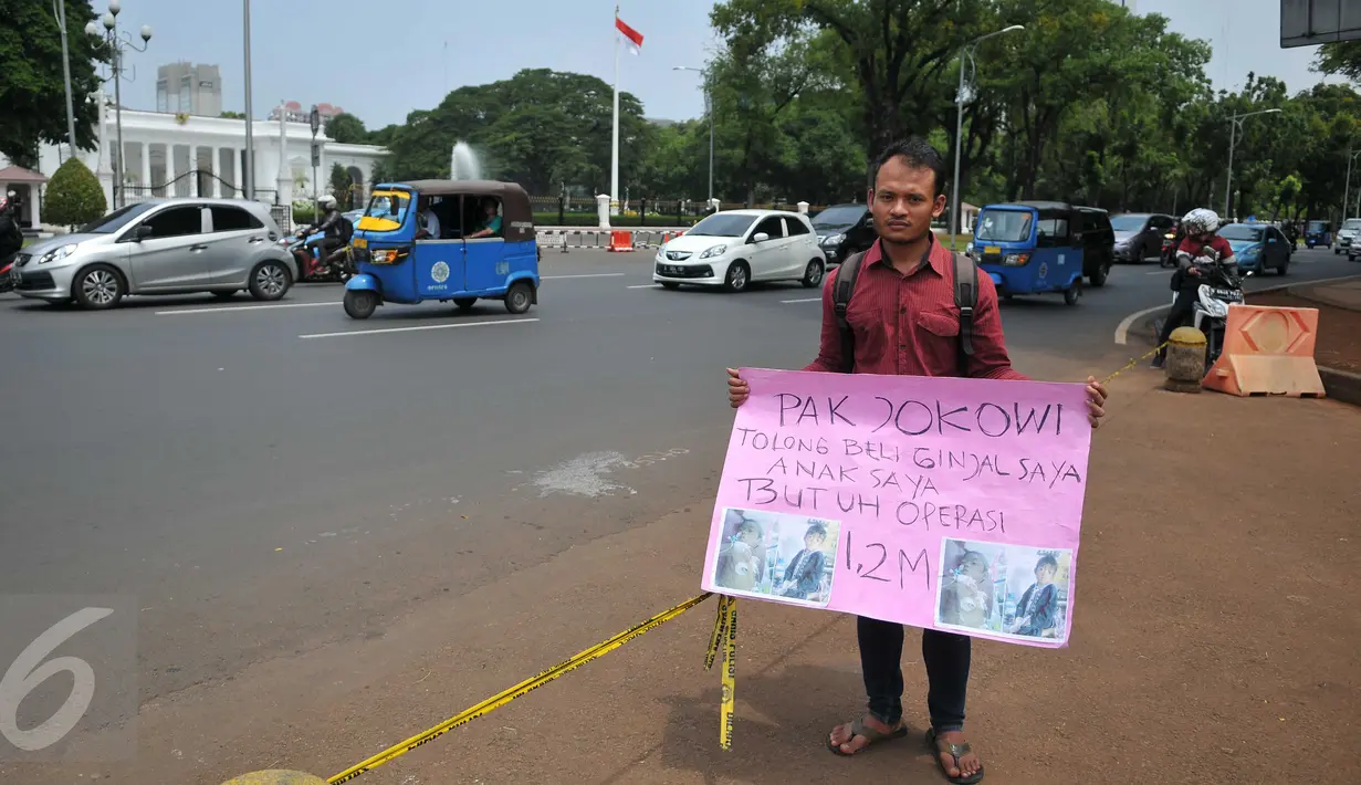 Aksi Susanto asal Pandeglang, Banten, di depan Istana Merdeka, Jakarta, Jumat (20/11). Bapak ini meminta Presiden Jokowi membeli ginjalnya guna membiayai operasi transplantasi hati anaknya yang disinyalir mencapai Rp.1,2M. (Liputan6.com/Gempur M Surya)