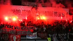 Suporter membentangkan spanduk bertuliskan "Obrigado Teco, You Made Us Dream" dengan menyalakan flare di Stadion Kapten I Wayan Dipta usai pertandingan menghadapi Madura United. (Bola.com/Alit Binawan)