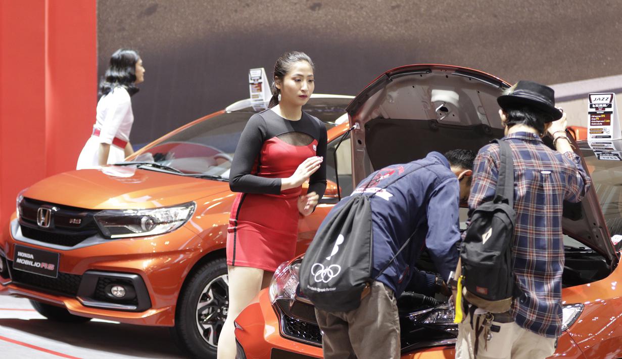 Sales Promotion Girl (SPG) berada di depan kendaraan yang dipamerkan di GIIAS 2019, ICE BSD, Kamis (25/7). Kehadiran SPG tersebut selain untuk menarik perhatian pengunjung juga bisa memberikan informasi tentang produk. (Bola.com/M Iqbal Ichsan)