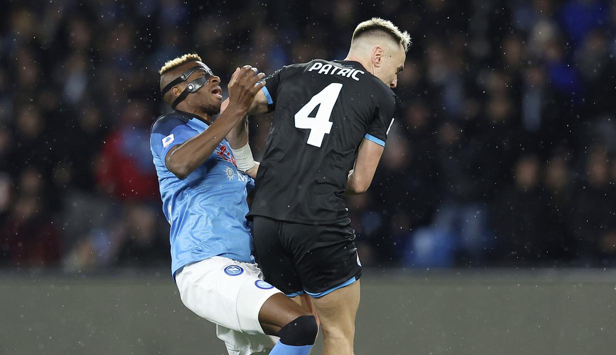Pemain Napoli, Victor Osimhen diadang pemain Lazio, Patric, pada laga Liga Italia di Stadion Diego Armando Maradona, Sabtu (4/3/2023). Napoli menelan kekalahan saat menjamu Lazio pada pekan ke-25 Serie A 2022/2023. 
(Alessandro Garofalo/LaPresse via AP)