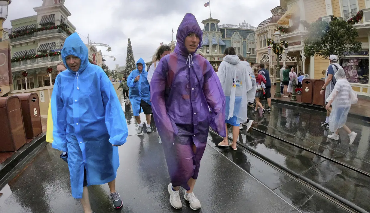 <p>Pengunjung menantang cuaca saat kondisi memburuk dengan mendekatnya Badai Nicole ke kawasan Walt Disney World di Lake Buena Vista, Florida, Rabu (9/11/2022). Semua taman Disney di Florida Tengah ditutup Rabu pagi karena badai yang akan datang. (Joe Burbank/Orlando Sentinel via AP)</p>