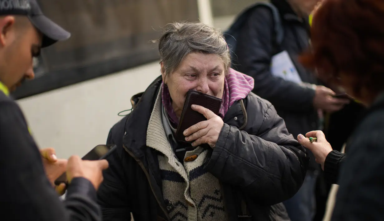 <p>Seorang perempuan diproses saat dia tiba dengan bus bersama orang lain yang melarikan diri dari Mariupol dan kota-kota lain ke pusat penerimaan pengungsi di Zaporizhzhia, Ukraina, Selasa (3/5/2022). Ribuan warga Ukraina terus meninggalkan wilayah yang diduduki Rusia. (AP Photo/Francisco Seco)</p>