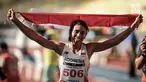 Atlet Lompat Jauh Indonesia, Maria Natalia Londa membawa bendera Merah Putih usai berlaga di nomor triple jump putri SEA Games di Stadium Bukit Jalil, Malaysia, Rabu (23/8). (Liputan6.com/Faizal Fanani)