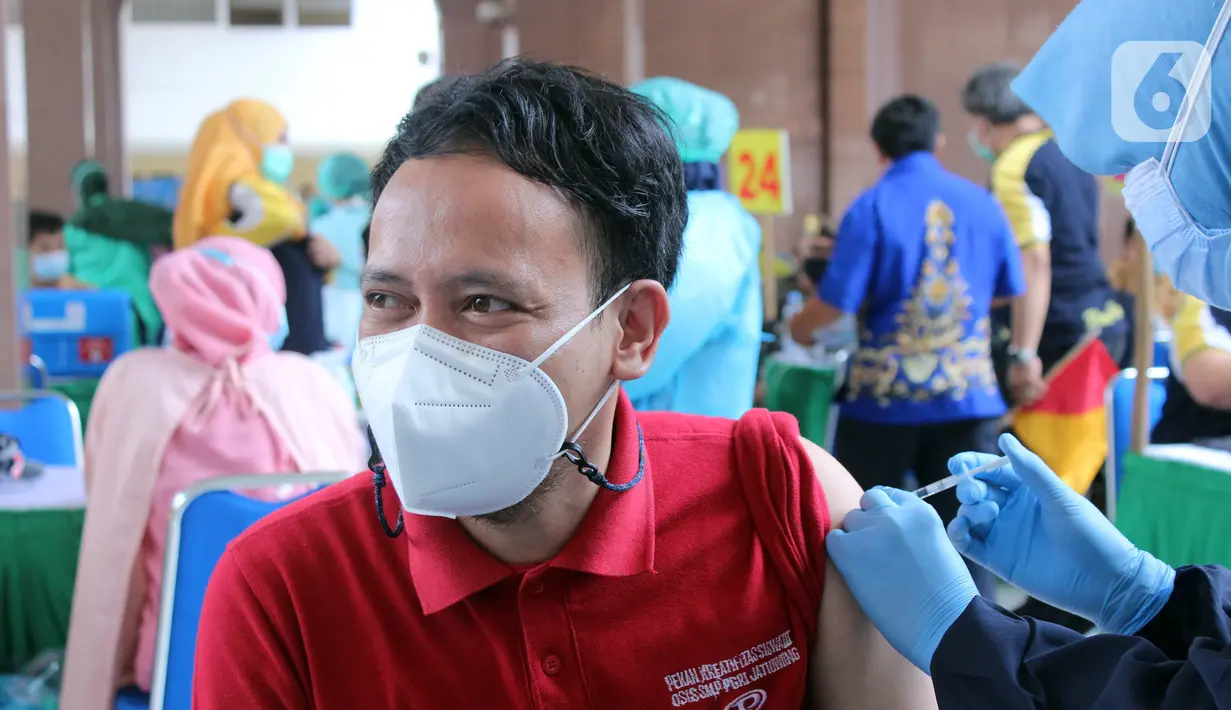 Vaksinator menyuntikkan vaksin COVID-19 Sinovac ke seorang guru saat vaksinasi massal di Gedung Pemerintah Kota Tangerang, Banten, Kamis (25/2/2021). Sebanyak 6.000 petugas pelayanan publik dan guru di Kota Tangerang menjalani vaksinasi COVID-19. (Liputan6.com/Angga Yuniar)