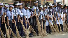 Sejumlah pelajar India membawa sapu saat mengambil bagian dalam 'Swachh Bharat Abhiyan' atau kampanye kebersihan di Hyderabad (12/2). Kampanye ini bertujuan untuk membersihkan jalanan dan infrastruktur di kota-kota India. (AFP Photo/Noah Seelam)