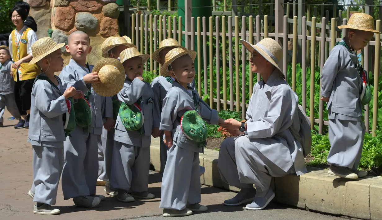 Para biksu cilik beristirahat ketika mereka mengunjungi taman hiburan Everland di Yongin, Korea Selatan, Kamis (2/5). (Jung Yeon-je/AFP)