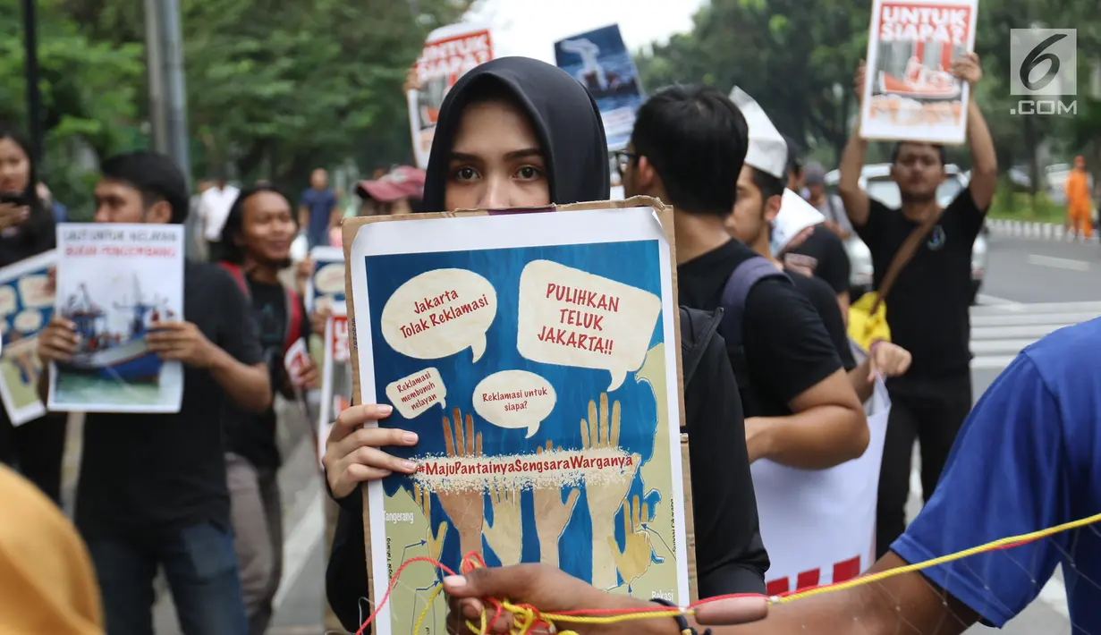 Massa yang tergabung dalam Koalisi Selamatkan Teluk Jakarta menggelar aksi jalan mundur menuju Balai Kota di Jakarta, Senin (24/6). Dalam aksinya mereka meminta kepada Gubernur DKI Jakarta untuk mencabut kembali keputusan penerbitan IMB di Pulau C dan D reklamasi Teluk Jakarta. (Liputan6.com/Angga Y
