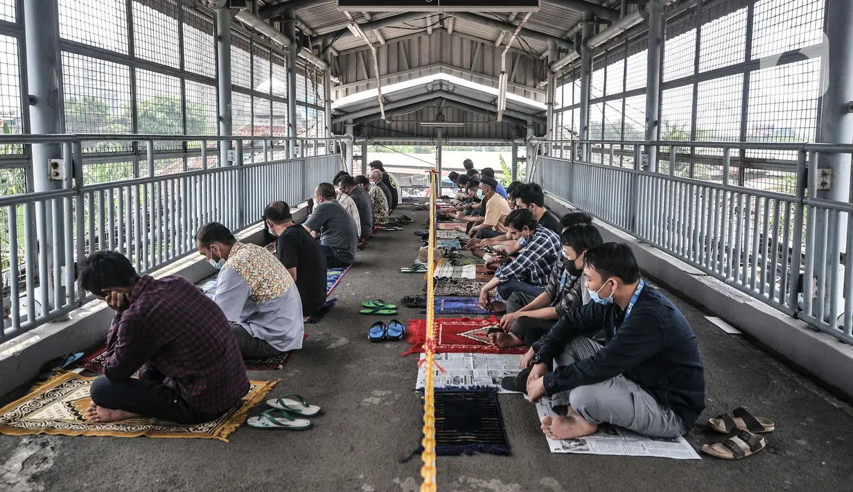 Umat Islam mendengarkan ceramah saat menunaikan salat Jumat di Stasiun Kampung Bandan, Jakarta, Jumat (7/5/2021). Sebagian jemaah menjadikan peron stasiun sebagai tempat salat dan sebagian lain berada di tangga serta jembatan penyeberangan. (merdeka.com/Iqbal S. Nugroho)