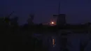 Super Moon terbit di atas kincir angin di Oostzaan, Belanda, Kamis (11/8/2022). Bulan Purnama Agustus 2022 akan menjadi fenomena Supermoon terakhir tahun ini. Bulan Purnama Agustus dijuluki "Sturgeon Moon". (AP Photo/Peter Dejong)