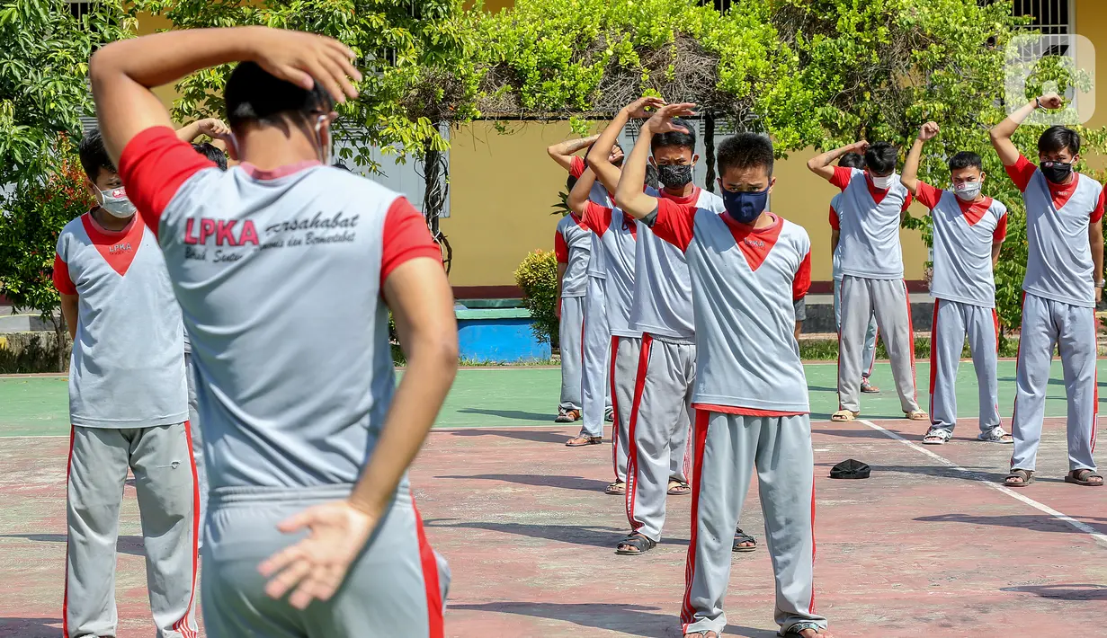 Anak binaan melakukan peregangan otot atau stretching di lapangan Lembaga Pembinaan Khusus Anak (LPKA) Klas 1 Tangerang, Banten, Sabtu (30/5/2020). Stretching selama 15-20 menit dapat meningkatkan fleksibilitas dan sirkulasi selama pandemi Covid-19. (Liputan6.com/Fery Pradolo)