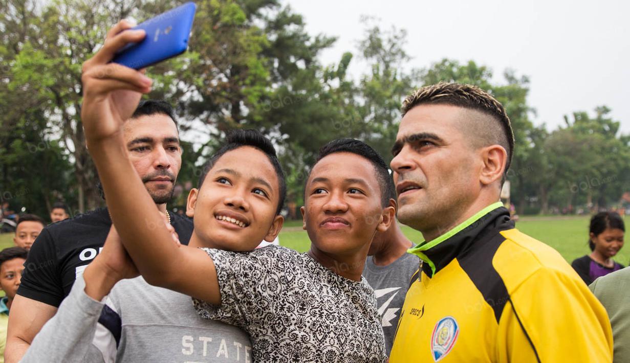 Striker Arema Cronus, Cristian Gonzales, dengan ramah melayani permintaan warga untuk foto bareng usai latihan di Lapangan Kostrad, Bogor, Jawa Barat, Sabtu (30/7/2016). (Bola.com/Vitalis Yogi Trisna)