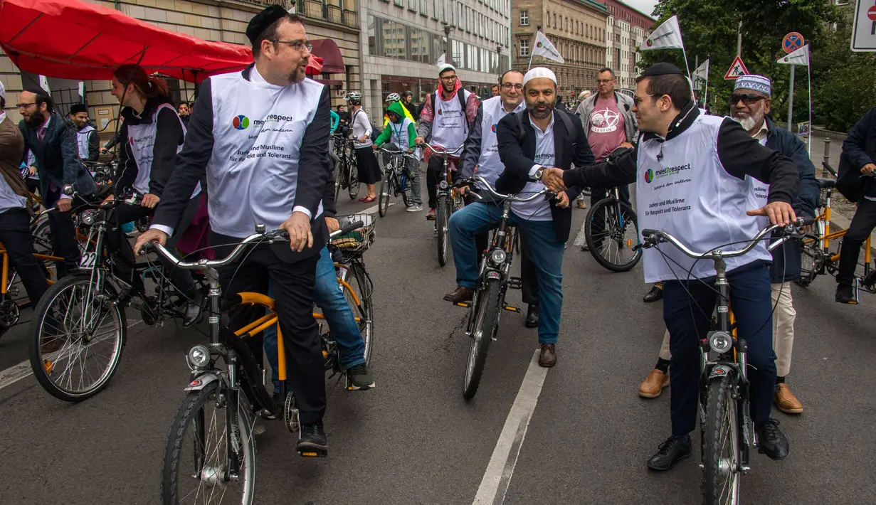 Warga Yahudi dan Muslim mengayuh sepeda tandem sebagai kampanye lintas agama di Berlin, Jerman, 24 Juni 2018. Selain 25 komunitas lintas agama, puluhan orang bergabung dalam tur sepeda ini untuk menunjukkan solidaritas. (AFP/John MACDOUGALL)