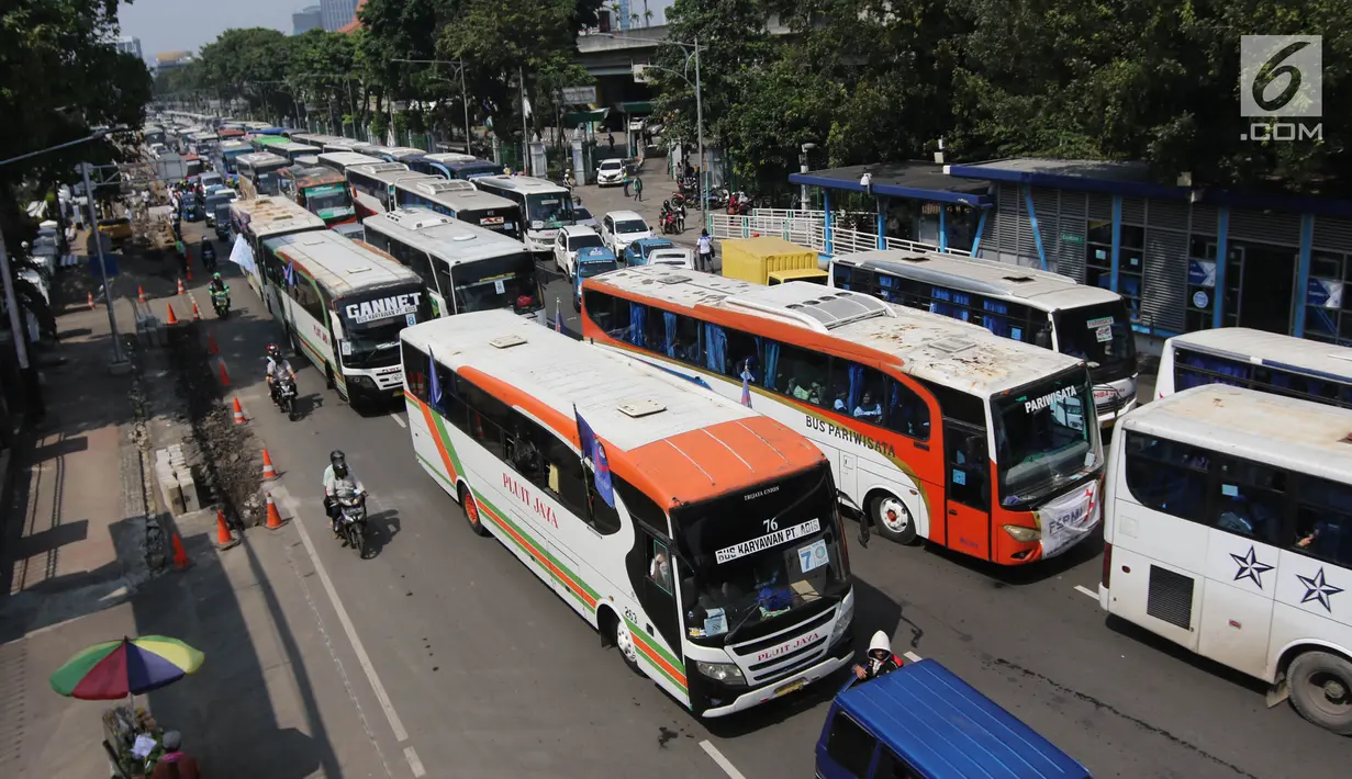 Suasana di Jalan Medan Merdeka Timur saat dipadati puluhan bus yang mengangkut buruh, Jakarta, Selasa (1/5). Memperingati Hari Buruh yang jatuh setiap tanggal 1 Mei, sejumlah organisasi pekerja mengadakan demonstrasi. (Liputan6.com/Arya Manggala)