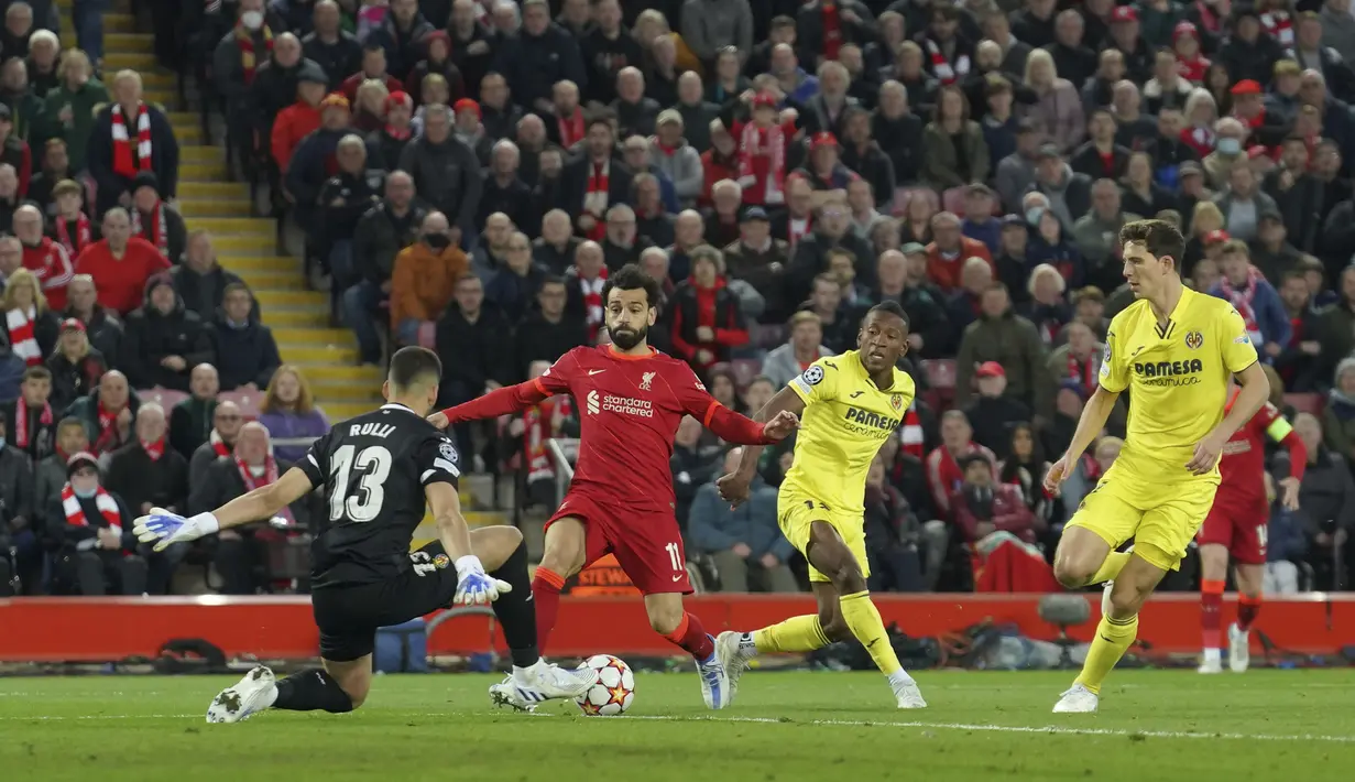 <p>Penjaga gawang Villarreal Geronimo Rulli melakukan penyelamatan di depan pemain Liverpool Mohamed Salah saat pertandingan leg pertama semifinal Liga Champions di stadion Anfield di Liverpool, Inggris, Kamis (28/4/2022). Liverpool menang atas Villarreal 2-0. (AP Photo/Jon Super)</p>