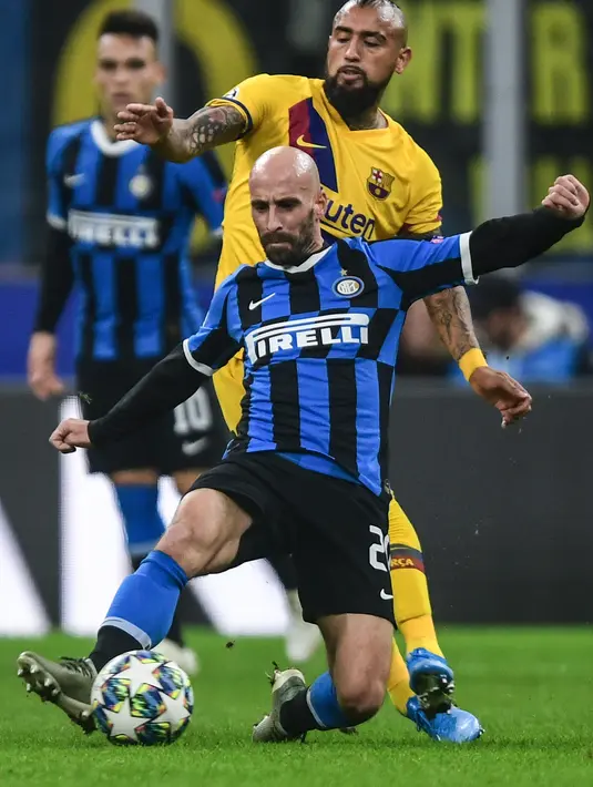 Gelandang Barcelona, Arturo Vidal berusaha merebut bola dari gelandang Inter Milan, Borja Valero pada pertandingan Grup F Liga Champions di stadion San Siro di Milan pada 10 Desember 2019. (AFP/Miguel Medina)