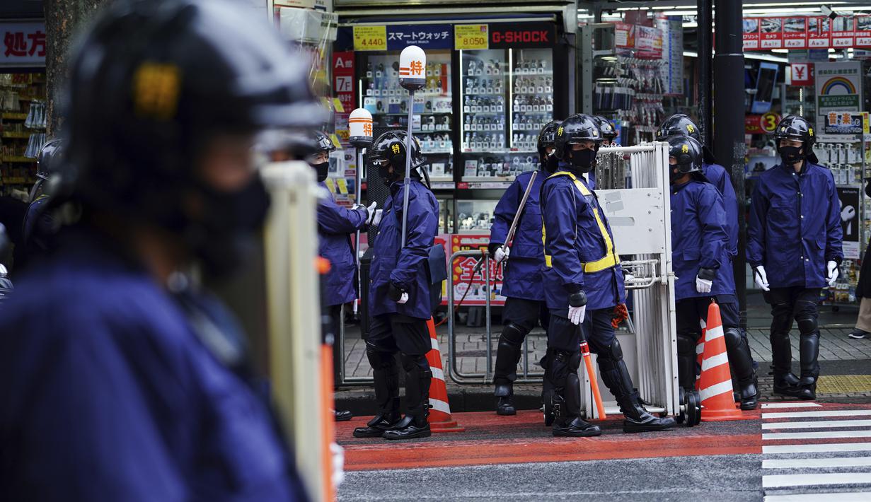 Petugas polisi berjaga di dekat jalan menuju penyeberangan pejalan kaki di awal liburan "Minggu Emas" Jepang di distrik Shibuya di Tokyo (29/4/2021). Khusus di Jepang Golden Week atau Minggu Emas memiliki serangkaian hari libur resmi. (AP Photo/Eugene Hoshiko)