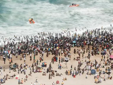 Ribuan wisatawan bersuka ria saat perayaan Tahun Baru di North Pier Beach, Durban, Afrika Selatan, 1 Januari 2022. Menurut polisi Afrika Selatan, hampir 50 ribu orang diperkirakan akan menghabiskan hari di pantai. (Rajesh JANTILAL/AFP)