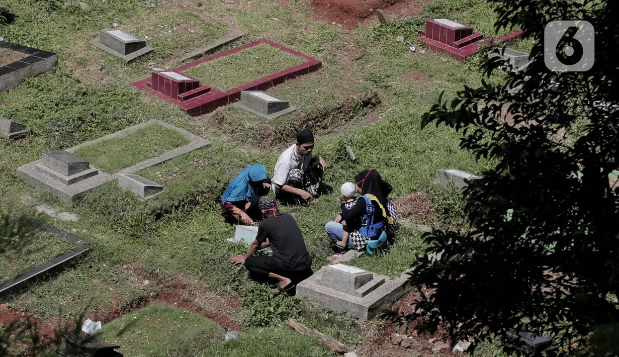 Warga berziarah kubur di makam keluarga pada hari kedua Lebaran di TPU Kebagusan, Jakarta, Senin (25/5/2020). Tradisi ziarah kubur saat Idul Fitri yang biasa dilakukan muslim relatif sepi dibandingkan tahun-tahun sebelumnya dikarenakan pandemi corona covid-19. (Liputan6.com/Johan Tallo)