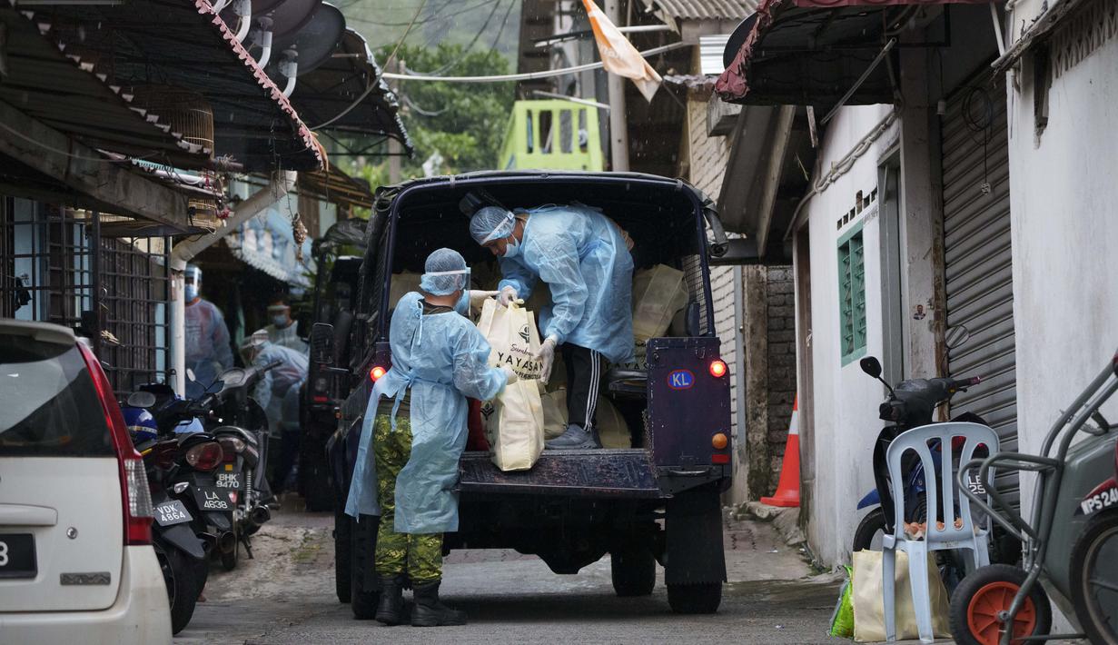 Petugas mendistribusikan kebutuhan pokok di kawasan Segambut Dalam yang berada di bawah Enhanced Movement Control Order (EMCO) akibat peningkatan drastis jumlah kasus COVID-19 yang tercatat selama 10 hari terakhir di Kuala Lumpur, Malaysia, Minggu (27/6/2021). (AP Photo/Vincent Thian)