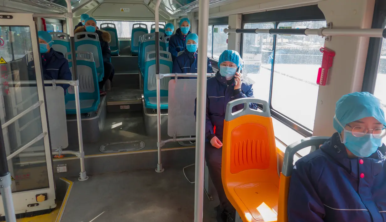 Para petugas medis dari Rumah Sakit Afiliasi Universitas Qingdao duduk berjauhan dalam bus untuk mencegah risiko infeksi silang virus corona saat mereka kembali ke hotel setelah bekerja di Wuhan, China pada 20 Februari 2020. (Xinhua/Cai Yang)