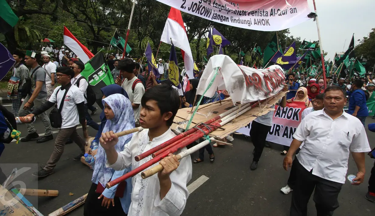Massa aksi membawa keranda saat melintas di Jalan Medan Merdeka Selatan, Jakarta, Jumat (4/11). Dalam aksinya, massa menuntut agar polisi segera menangkap Gubernur Nonaktif Basuki T Purnama atas dugaan penistaan agama. (Liputan6.com/Immanuel Antonius)