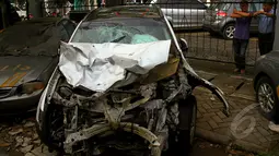 Mobil Mitsubishi Outlander yang mengalami kecelakaan di kawasan Pondok Indah terlihat rusak parah pada bagian depan, Polres Jakarta Selatan, Rabu (21/1/2015). (Liputan6.com/Faisal R Syam)