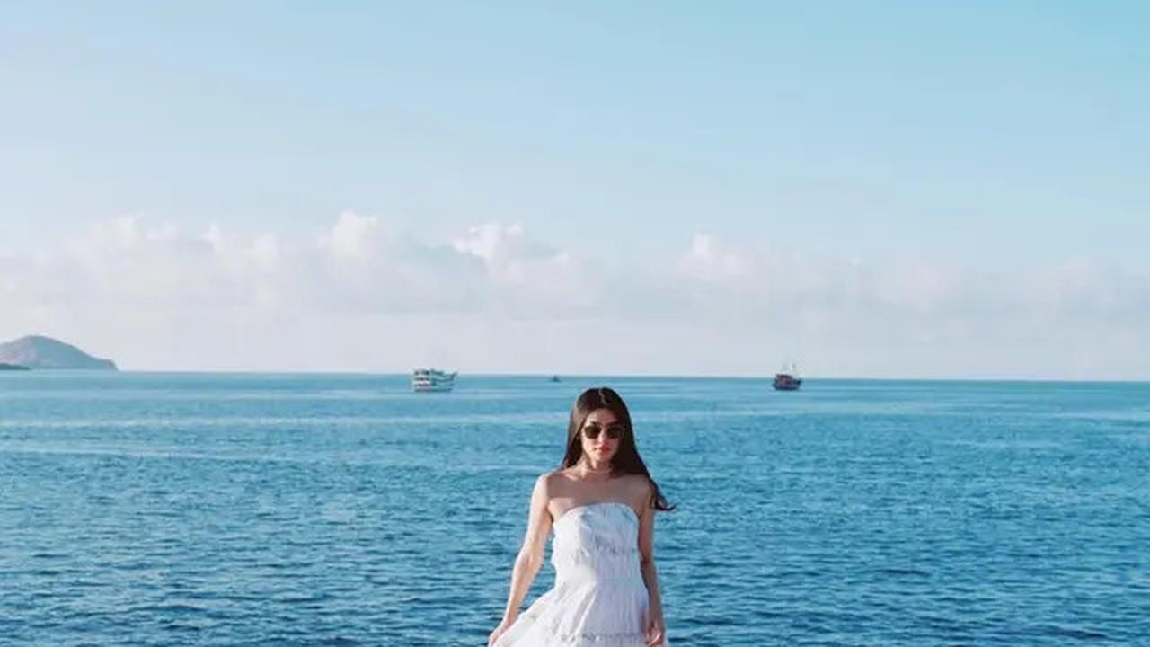 Dengan pemandangan laut biru yang luas di belakangnya, ibu dua anak ini tampak anggun saat berpose.<br>