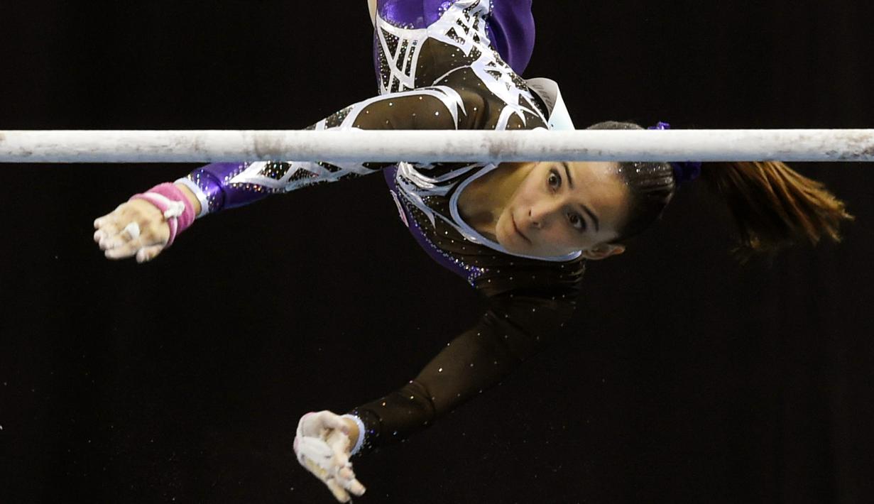 Salah satu aksi pesenam cantik Malaysia, Farah Ann Abdul Hadi saat menggunakan palang tunggal pada  SEA Games 2015 di Singapore, (9/9/2015). Farah akan kembali tampil pada SEA Games 2017 di Malaysia. (AFP/Roslan Rahman)