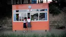 Foto pada 18 Juli 2017 menunjukkan dua pelajar Korea Utara berhenti di sebuah kios bunga di Pyongyang, Korea Utara. (AP Photo/Wong Maye-E)