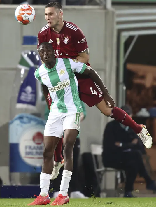 Penyerang Greuther Fuerth, Dickson Abiama dan bek Bayern Munchen Niklas Sule berebut bola pada pekan keenam Liga Jerman 2021/2022 di Trolli Arena, Sabtu (25/9/2021) dini hari WIB. Die Roten –julukan Bayern Munchen – menang 3-1 atas tim promosi Greuther Furth. (Daniel Karmann/dpa via AP)