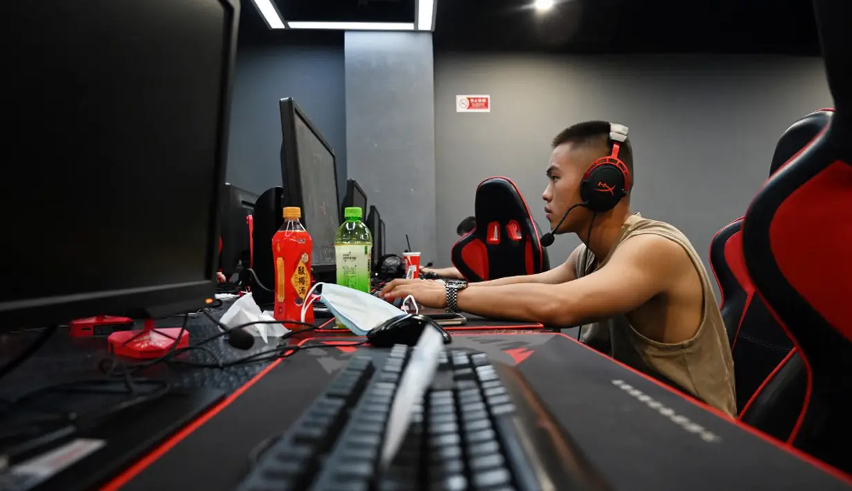 Seorang pria bermain game komputer di sebuah kafe internet di Beijing, China, Jumat (10/9/2021). Anak di bawah 18 tahun di China kini dilarang bermain game online dari hari Senin sampai Kamis. (GREG BAKER/AFP)